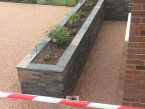 Resin Bound Driveway with New Side Wall and Raised Flower Beds in Rugby
